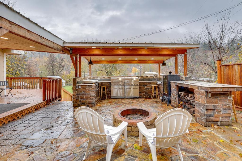 un patio con parrilla, sillas y fogata en Orofino Cottage - Patio, Hot Tub and Outdoor Kitchen, en Orofino