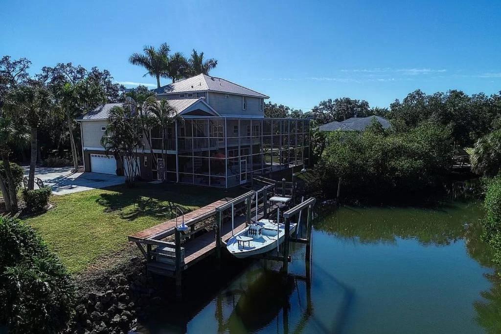 a large house with a boat docked at a dock at Manatee Cove in Englewood