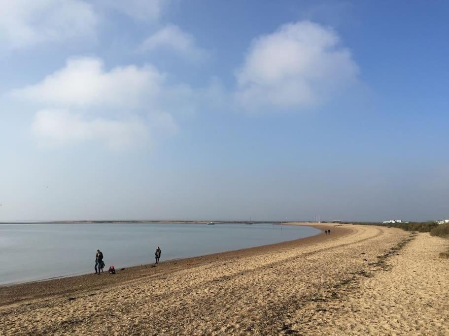 um grupo de pessoas caminhando em uma praia em A Seafood and Walking Enthusiasts Quiet Escape. em West Mersea