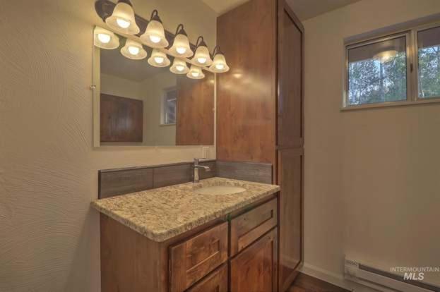 une salle de bain avec un lavabo et un miroir dans l'établissement The Gold Mine Cottage, à Idaho City