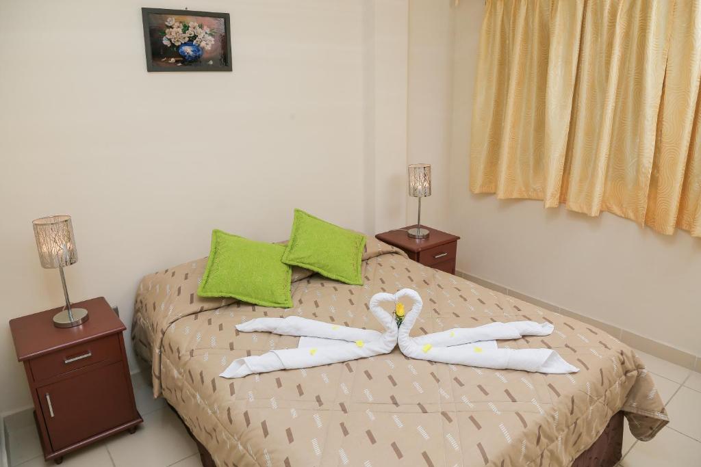 a bedroom with a bed with two pillows on it at HOSTAL PUNTA ARENAS in Tarija