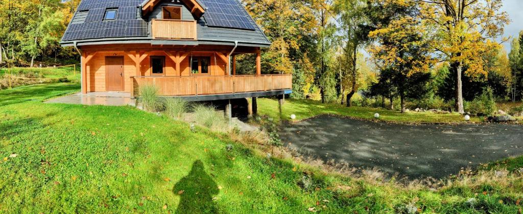 una casa con techo solar en la parte superior de un campo en Dom Pod Leśniczówką, en Zachełmie