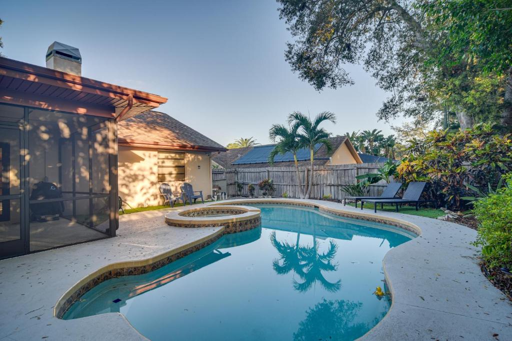 a swimming pool in the backyard of a house at Sunny Palm Harbor Home with Private Pool and Hot Tub! in Palm Harbor