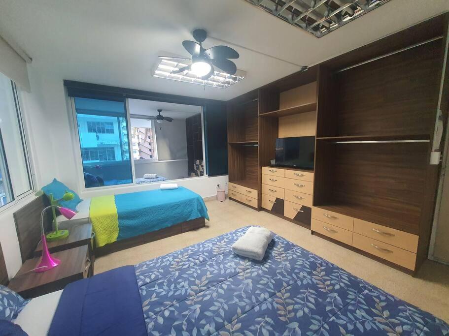 a bedroom with a bed and a dresser and a television at R-8 Amplio apartamento en zona turística. in Panama City