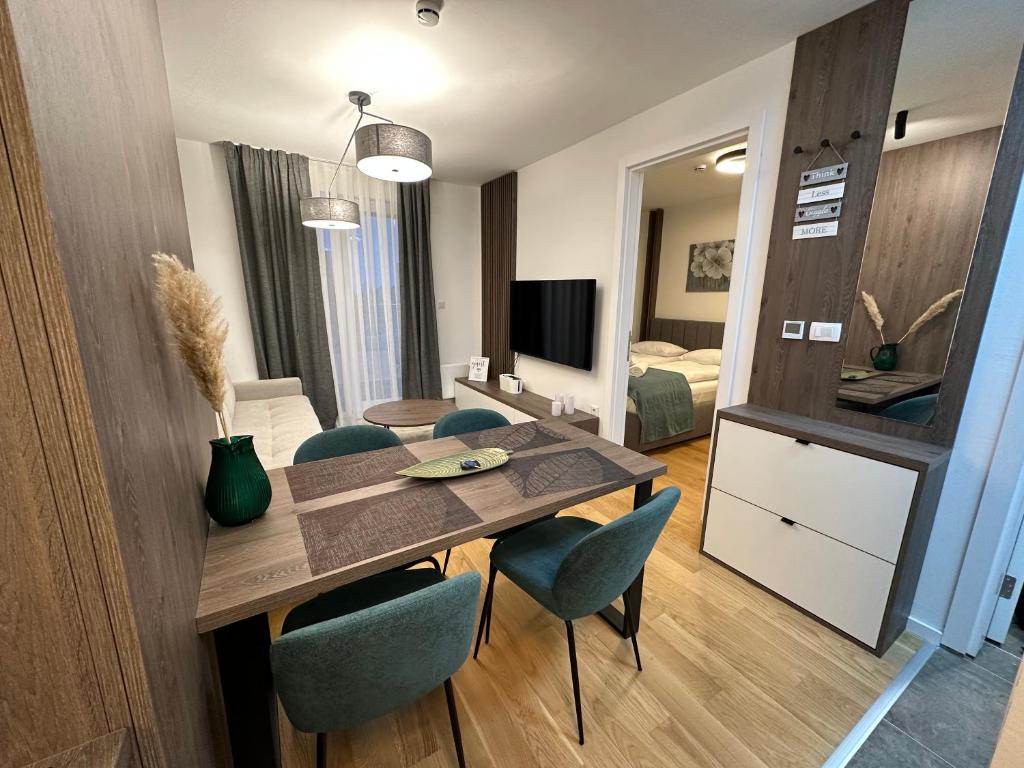 a living room with a dining room table and chairs at FORESTA Apartment Jahorina in Jahorina