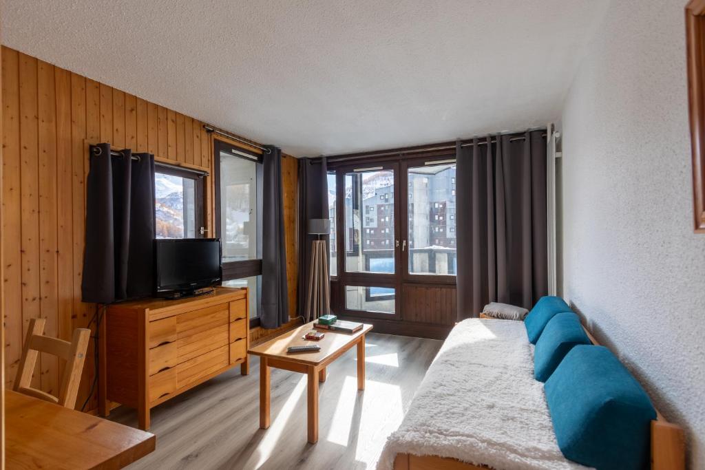 a living room with a couch and a tv at Val d'Isère - Pied des pistes 4 pers in La Daille