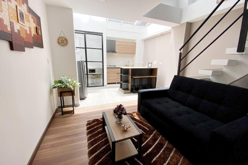 帕斯托的住宿－Hermoso Apartaestudio Duplex cerca a Unicentro，客厅配有黑色沙发和桌子