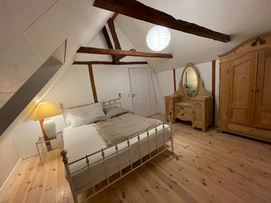 a bedroom with a bed and a dresser and a mirror at Byhus-lejlighed med sjæl og privat gårdhave in Hurup