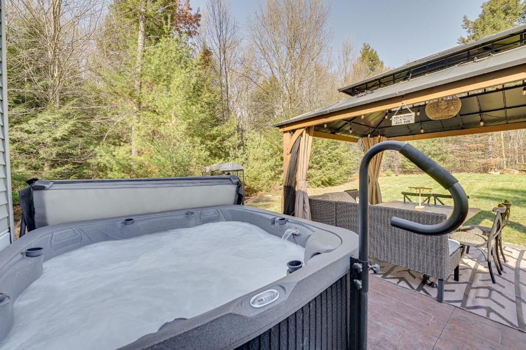 a hot tub on the back patio of a house at Northville Cabin with Fire Pit, 4 Mi to Boat Ramp! in Northville