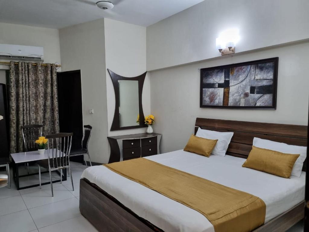 a bedroom with a bed and a dining room at Eniter Two Bedrooms Luxry Apartment in Karachi