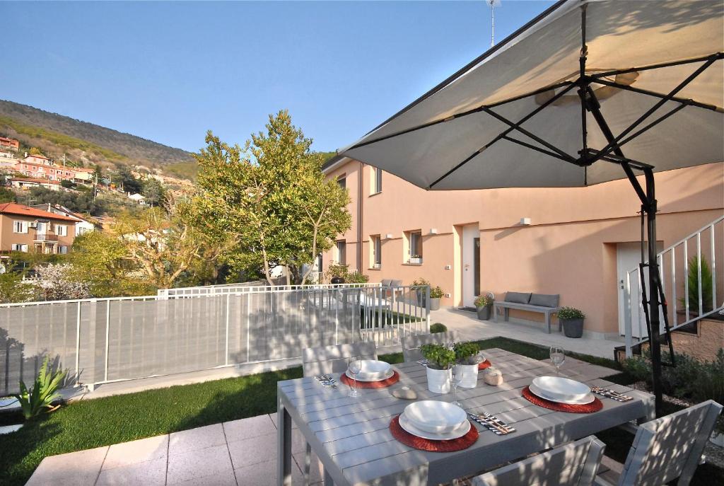 eine Terrasse mit einem Tisch und einem Sonnenschirm in der Unterkunft Casa Vacanze Barcola in Triest