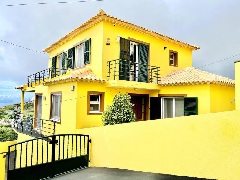 uma casa amarela com uma cerca em frente em Casa Amarela by Your Madeira Rentals em Ponta do Sol