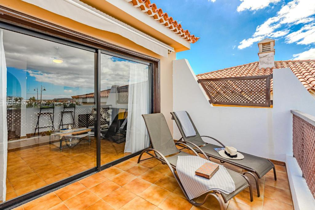 サンミゲル・デ・アボナにあるAlbatros Comfort Homeの椅子とバルコニー付きの客室です。