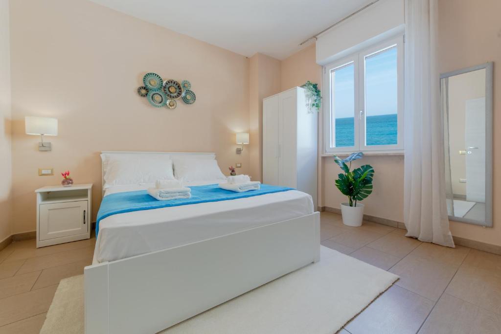 a white bedroom with a bed and a window at L'Affaccio Rooms - Lungomare Gallipoli in Gallipoli