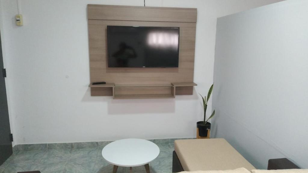 ein Wohnzimmer mit einem TV an einer weißen Wand in der Unterkunft Departamento Cerro Catedral in Neuquén