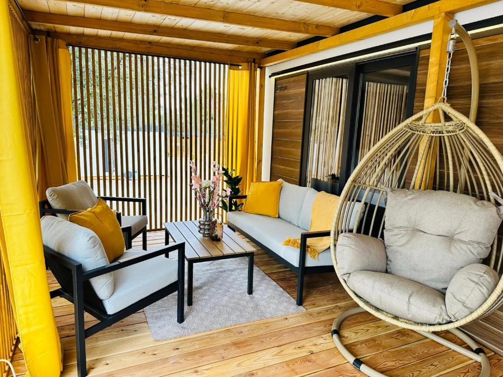 eine Veranda mit einer Schaukel und ein Wohnzimmer in der Unterkunft Sandra Holiday Homes in Biograd na Moru