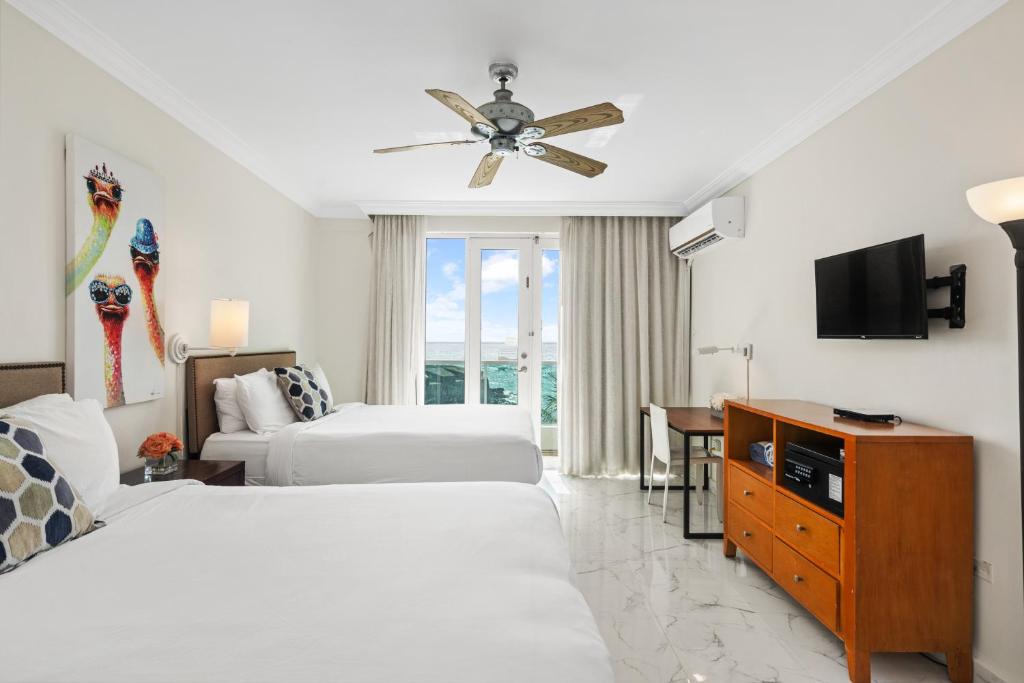 a hotel room with two beds and a television at Biarritz Studio - Beautiful Ocean View Studio in San Juan