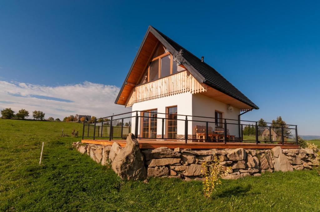 a house in a field with a stone wall at Kotelnica View in Groń