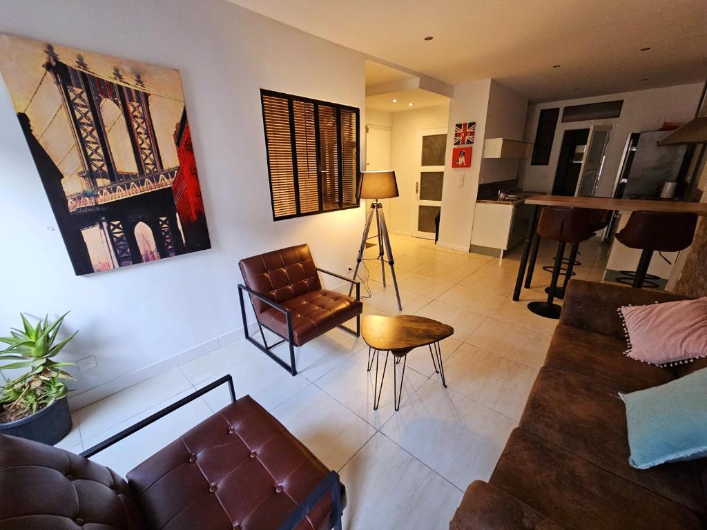 un salon avec un canapé et une chaise dans l'établissement Appartement cosy centre ville proche chantiers navals, calanques, plages, à La Ciotat