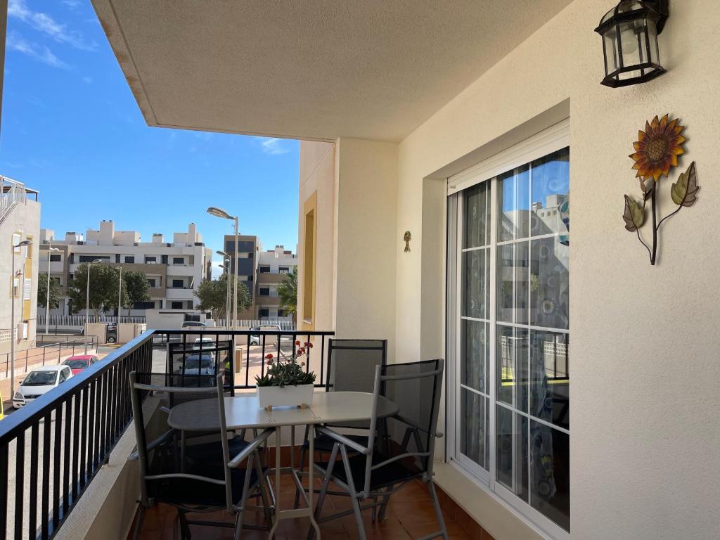 balcón con mesa, sillas y ventana en Apartamento del Toyo, en Almería