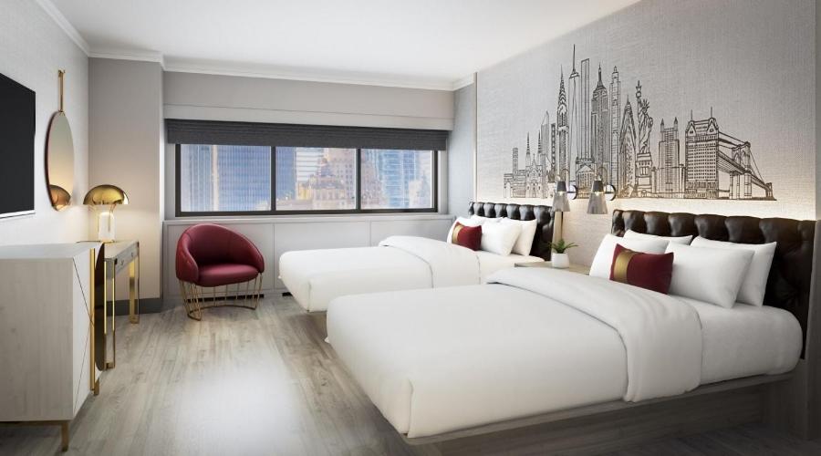 a bedroom with two white beds and a red chair at Executive Class at MTS Hotel in New York