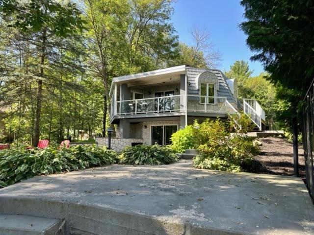 ein großes Haus mit einer Veranda und einer Auffahrt in der Unterkunft Waterfront Cottage in Muskoka in Severn