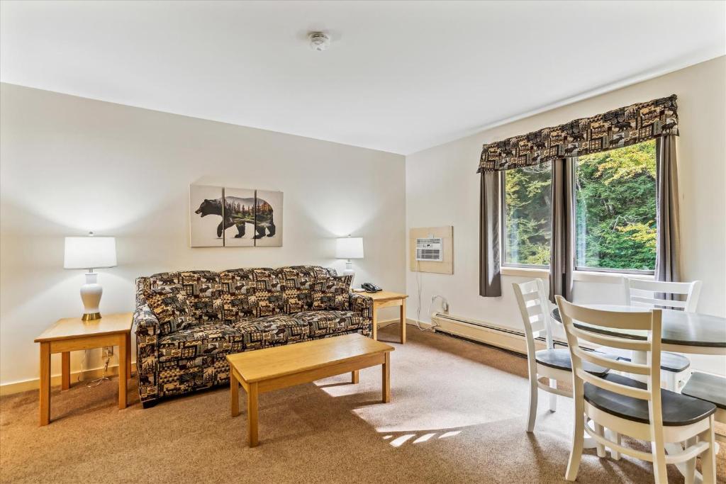 a living room with a couch and a table and chairs at Cedarbrook Deluxe one bedroom suite located on 2nd floor with outdoor heated pool 21820 in Killington