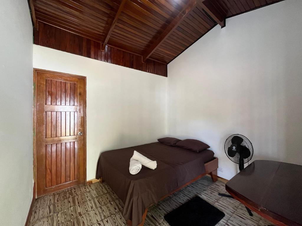 a bedroom with a bed and a wooden door at #3 Cabina Rústica para 2 personas en Paquera in Paquera