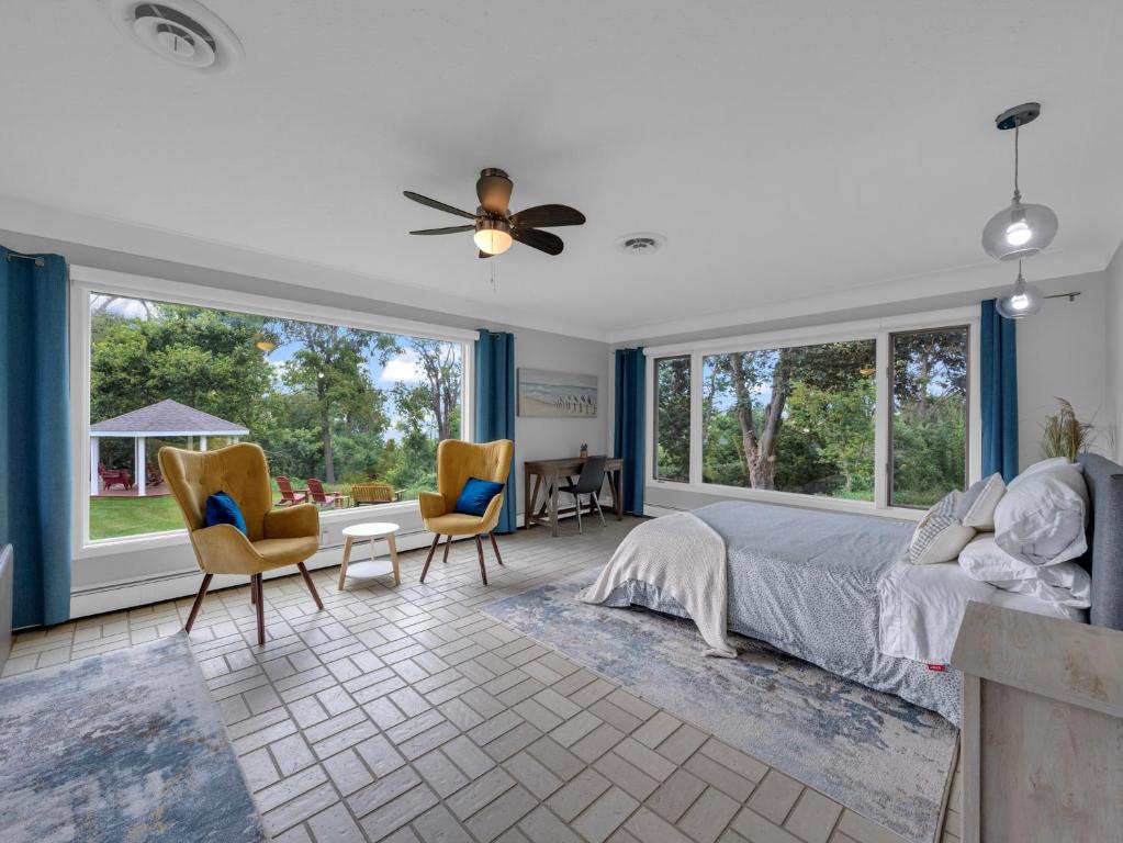 利明頓的住宿－Coastal Suite - Seacliff Beach Suites，一间卧室配有一张床、椅子和窗户。