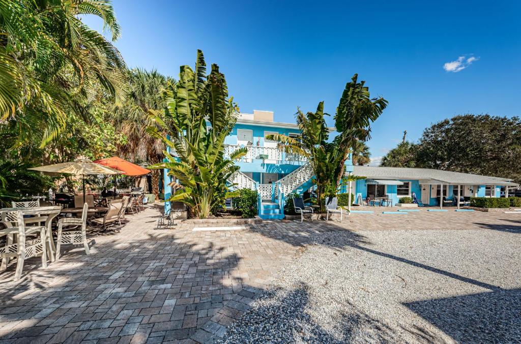 un resort con tavoli e sedie e un edificio di Blue Water Beachside Villa 6 a Clearwater Beach