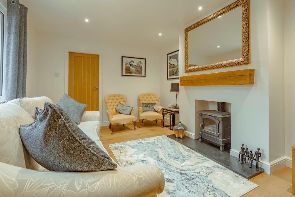 a living room with a white couch and a fireplace at Branlea - In the Heart of Ludlow in Ludlow