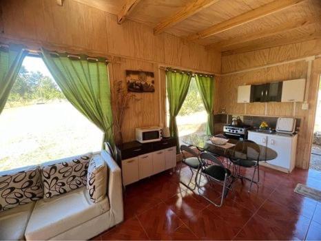 ein Wohnzimmer mit einem Sofa und einem Tisch in der Unterkunft Casa de campo in Lago Ranco