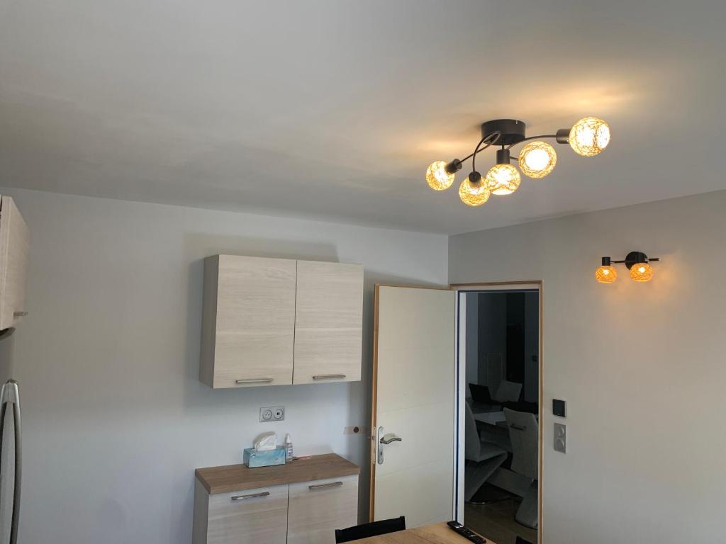 a kitchen with a ceiling light and a cabinet at Maison calme&#47;Chambre privée&#47;Clim+TV&#47;Pétit dejeuner inclu&#47;tout confort in Nevers