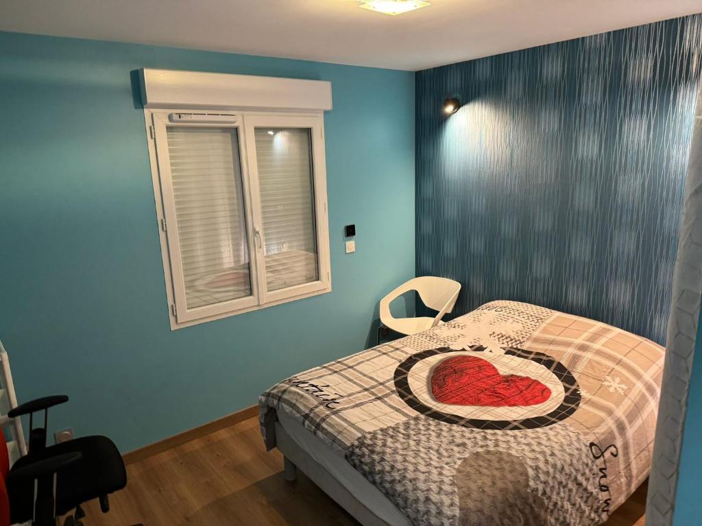 a bedroom with a bed with a heart pillow on it at Maison calme&#47;Chambre privée&#47;Clim+TV&#47;Pétit dejeuner inclu&#47;tout confort in Nevers