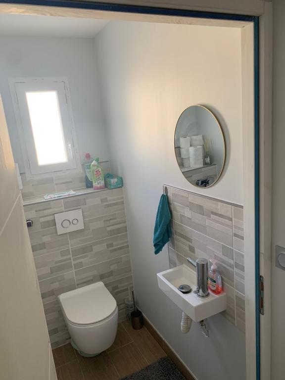 a bathroom with a toilet and a mirror at Maison calme&#47;Chambre privée&#47;Clim+TV&#47;Pétit dejeuner inclu&#47;tout confort in Nevers