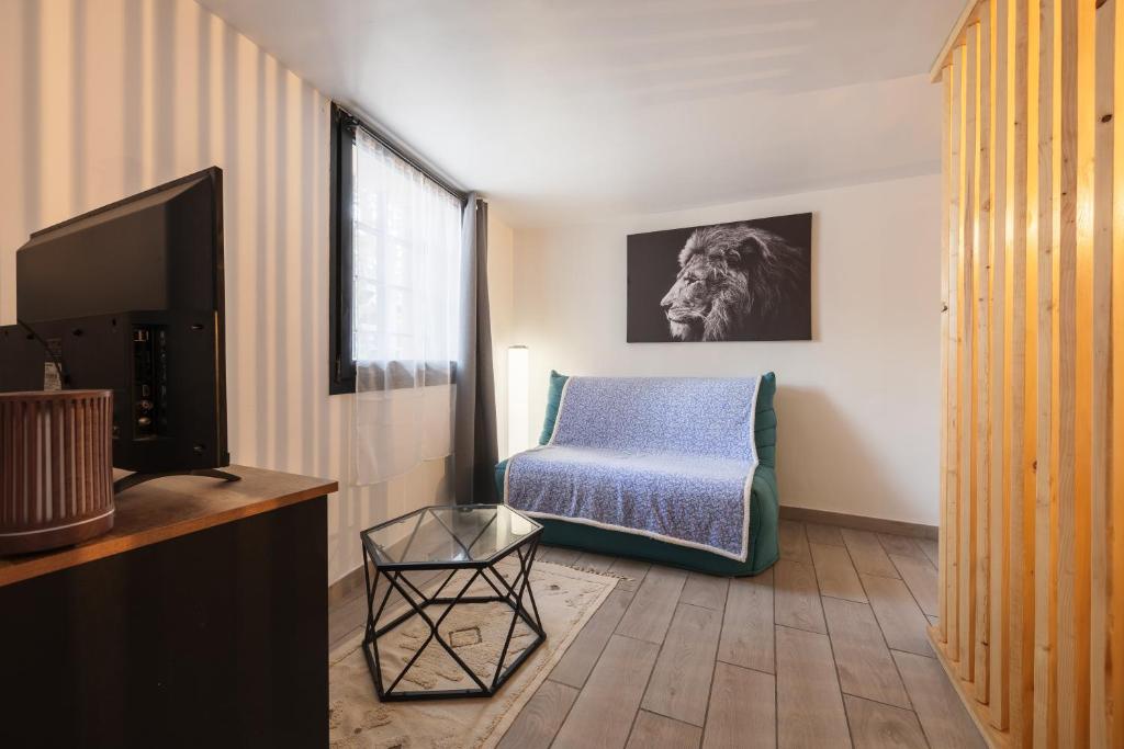 un salon avec une chaise et une télévision dans l'établissement Coin De Paradis au Coeur de Martigues RDC Wifi, à Martigues