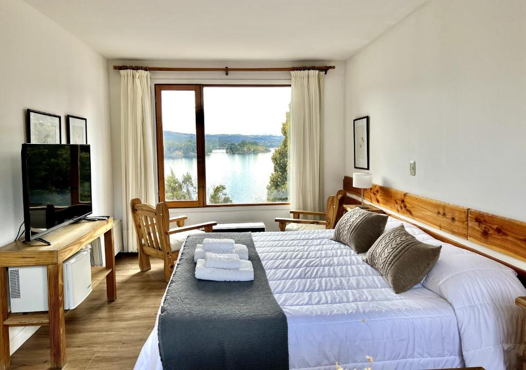 una camera da letto con un letto e una grande finestra di La Balconada by DOT Boutique a Villa Pehuenia