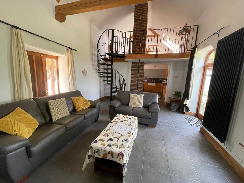 ein Wohnzimmer mit einem Sofa und einem Tisch in der Unterkunft The Ox House in Chewton Mendip