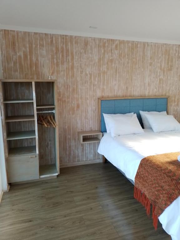 1 dormitorio con cama y estante para libros en Lodge Puerto Koupo, en Carahuo