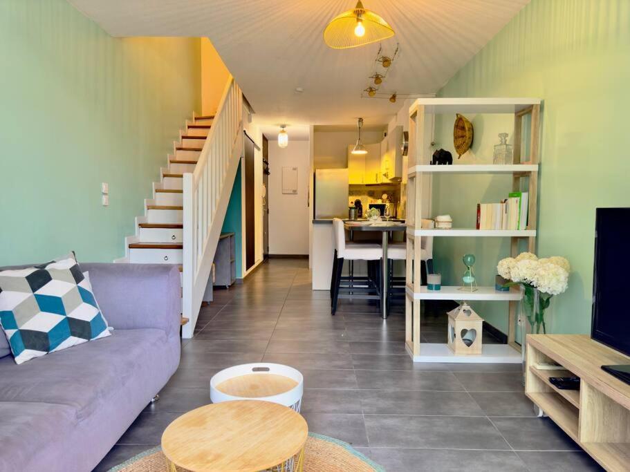 een woonkamer met een bank en een tafel bij Maison au calme 2 Chambres Terrasse Clim parking gratuit in Montpellier