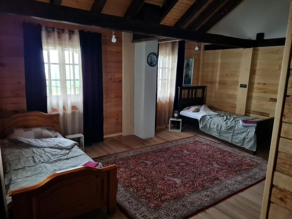 a bedroom with two beds and a rug at Eco Lodge Taor in Taor