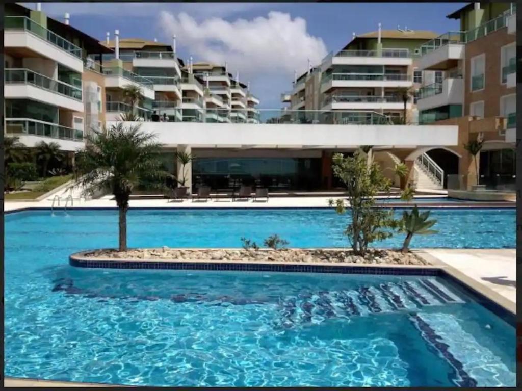a swimming pool in front of some apartment buildings at Praia do Santinho, de frente para mar in Florianópolis