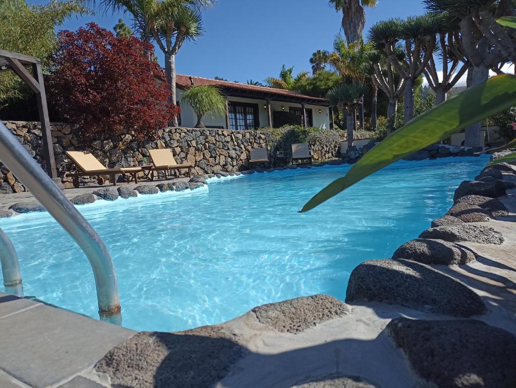 a swimming pool with blue water in a resort at EL PEDRAL in Los Llanos de Aridane