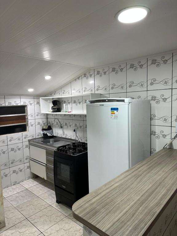 Il comprend une cuisine équipée d'un réfrigérateur et d'une cuisinière. dans l'établissement Casa baixinha, à Ubajara