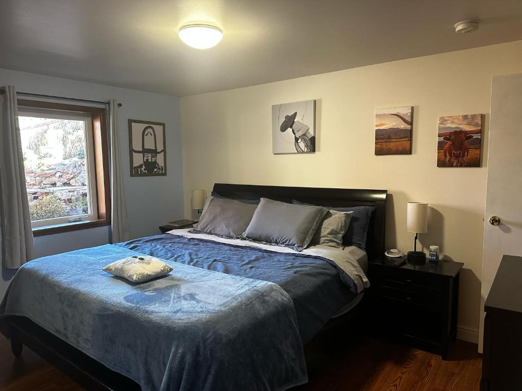 a bedroom with a bed with a blue comforter and a window at ATTACHED MOTHER-IN-LAW SUITE Soak in the hot tub, star gaze, enjoy the reservoir, hike, bike, kayak and more - Private floor, entrance, terrace and room and bathroom, not the full house in Fort Collins