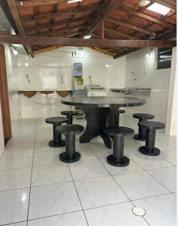 a table and stools in a room with a counter at Casa baixinha in Ubajara