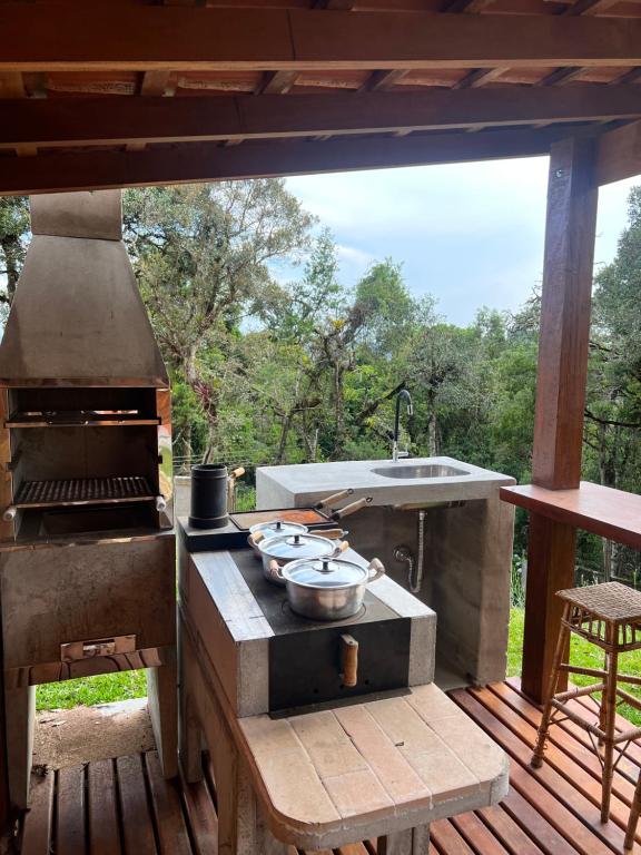 a outdoor kitchen with a stove and a sink at Vila husky pousada in Campos do Jordão
