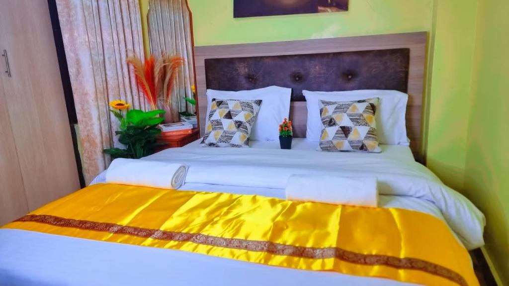 ein Schlafzimmer mit einem großen Bett und einer gelben Decke in der Unterkunft Luxe comfort AirBnB by Rosemary in Nairobi