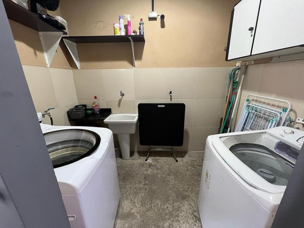 baño pequeño con lavadora y lavamanos en STUDIO 202 | WIFI 600MB | RESIDENCIAL JC, um lugar para ficar. en Belém