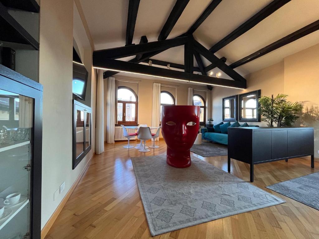 uma sala de estar com um vaso vermelho sobre uma mesa em Piazza Erbe Lodge em Verona